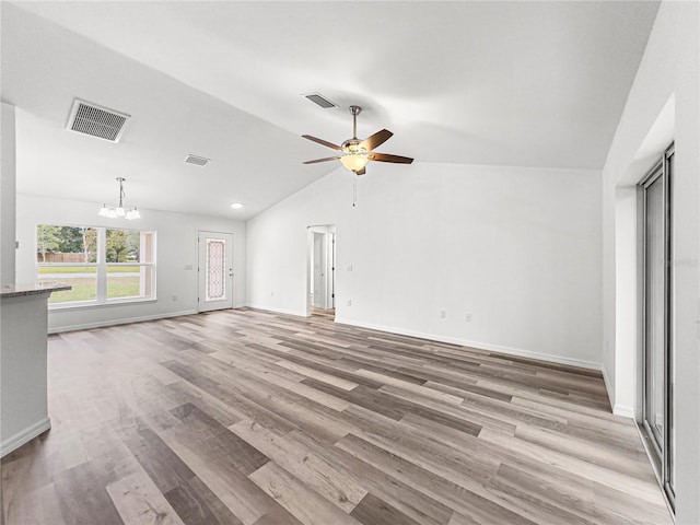 unfurnished living room featuring light wood-type flooring, ceiling fan with notable chandelier, and lofted ceiling