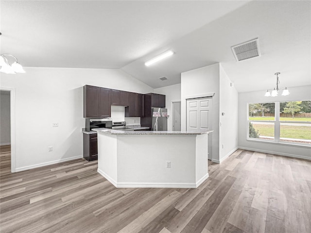 kitchen featuring stainless steel appliances, dark brown cabinets, vaulted ceiling, a chandelier, and light hardwood / wood-style flooring