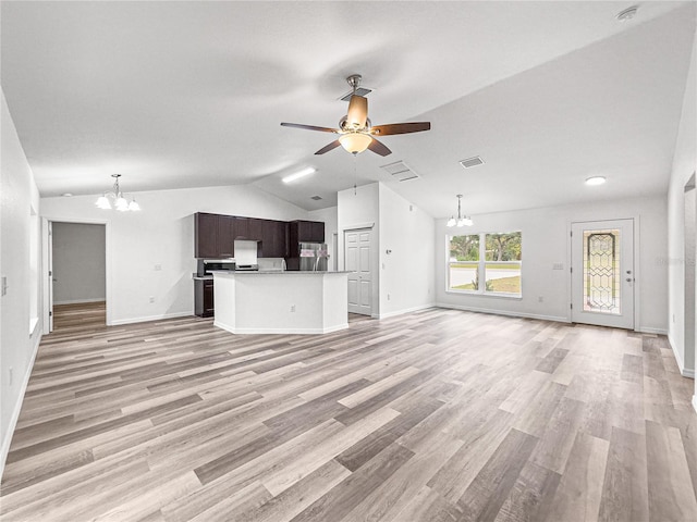 unfurnished living room featuring ceiling fan with notable chandelier, light hardwood / wood-style floors, and lofted ceiling