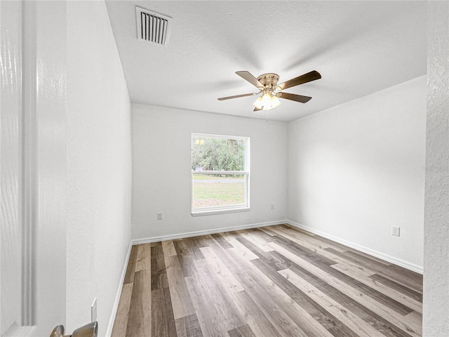 empty room featuring ceiling fan, a textured ceiling, and light hardwood / wood-style flooring