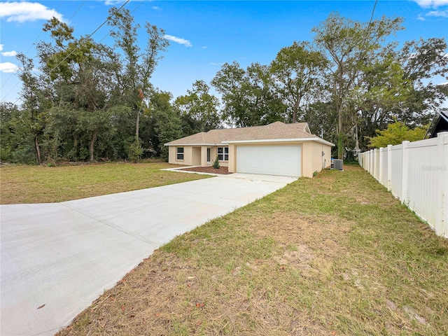 view of front of property featuring a garage, central AC, and a front lawn