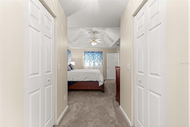 carpeted bedroom with ceiling fan and multiple closets