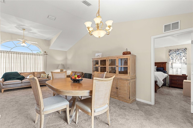 carpeted dining area with ceiling fan with notable chandelier and vaulted ceiling