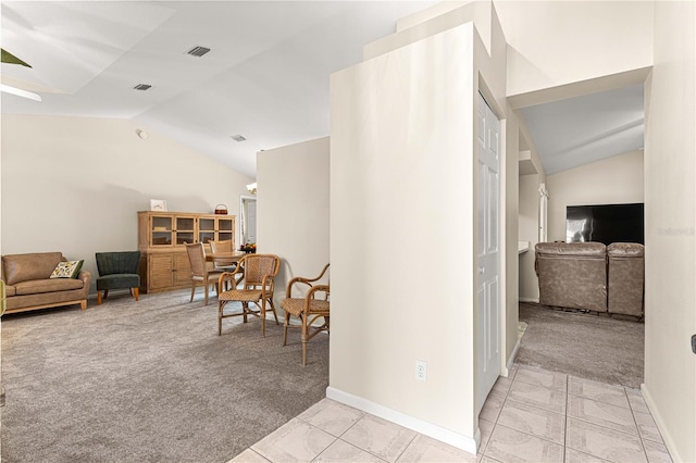 corridor featuring vaulted ceiling and light colored carpet