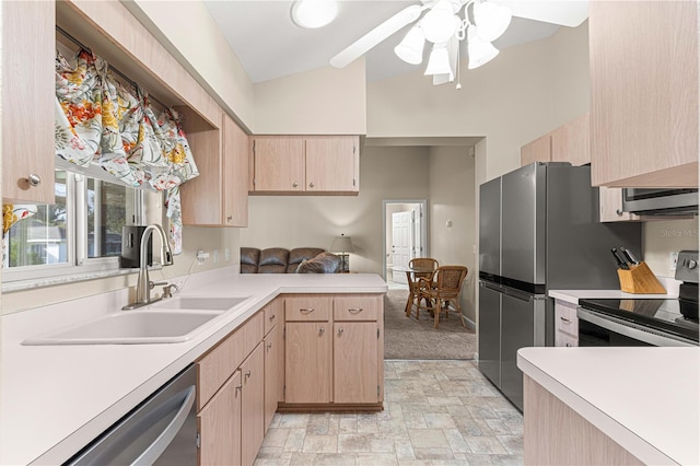 kitchen featuring stainless steel appliances, light brown cabinets, sink, kitchen peninsula, and lofted ceiling