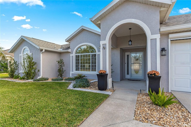 entrance to property featuring a garage and a yard