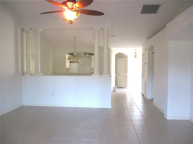 unfurnished room with decorative columns, light tile patterned floors, and ceiling fan