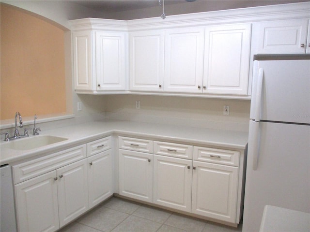 kitchen featuring white appliances, sink, light tile patterned floors, and white cabinets