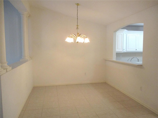 unfurnished dining area with an inviting chandelier and ornate columns