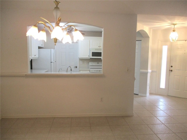 interior space featuring white cabinets, light tile patterned floors, ceiling fan, white appliances, and decorative light fixtures