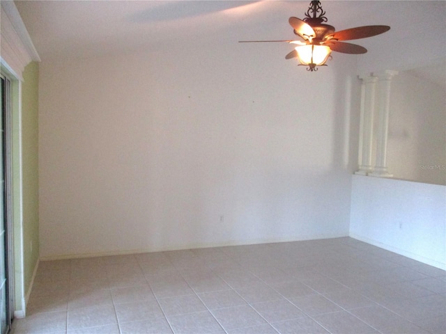 tiled spare room featuring ornate columns and ceiling fan