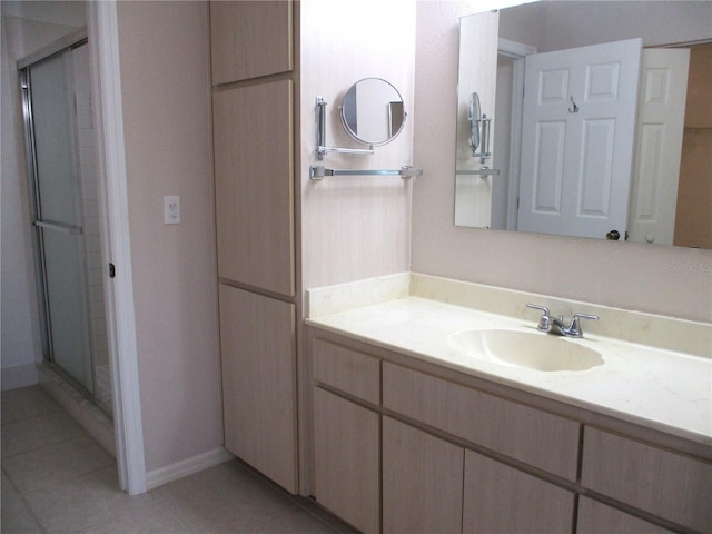 bathroom featuring vanity, a shower with shower door, and tile patterned flooring