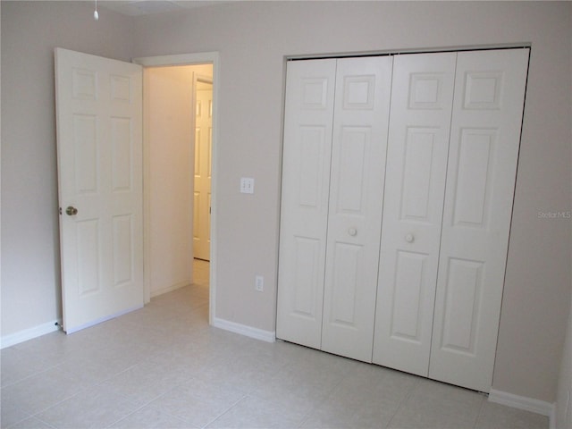 unfurnished bedroom featuring light tile patterned flooring and a closet