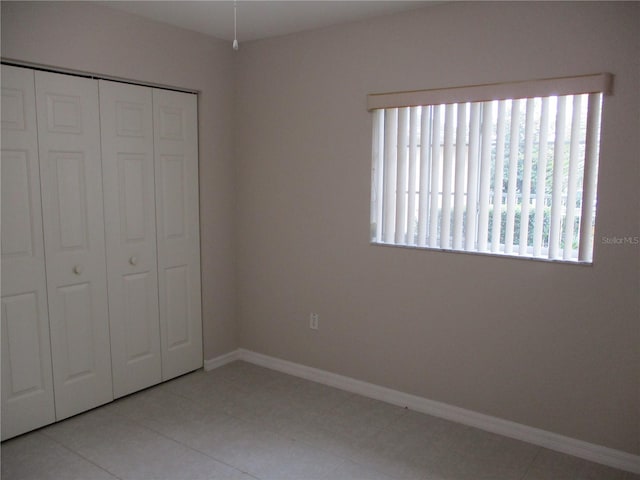 unfurnished bedroom with a closet and light tile patterned flooring