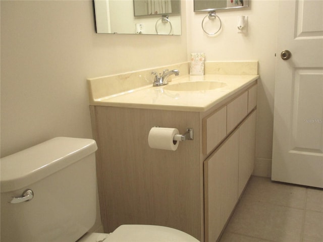 bathroom featuring tile patterned flooring, vanity, and toilet