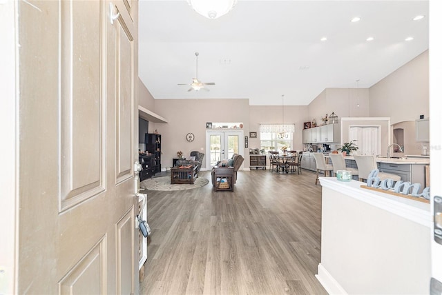 foyer featuring ceiling fan, sink, light hardwood / wood-style flooring, and high vaulted ceiling