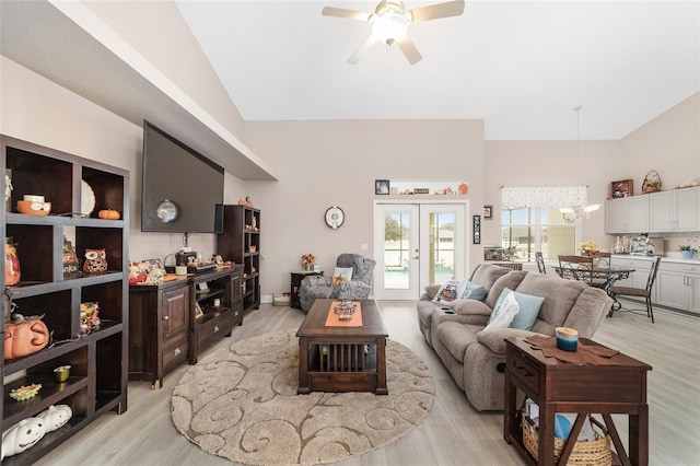 living room featuring ceiling fan, light wood-type flooring, and vaulted ceiling