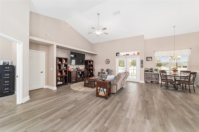 living room with high vaulted ceiling, french doors, hardwood / wood-style flooring, and ceiling fan with notable chandelier