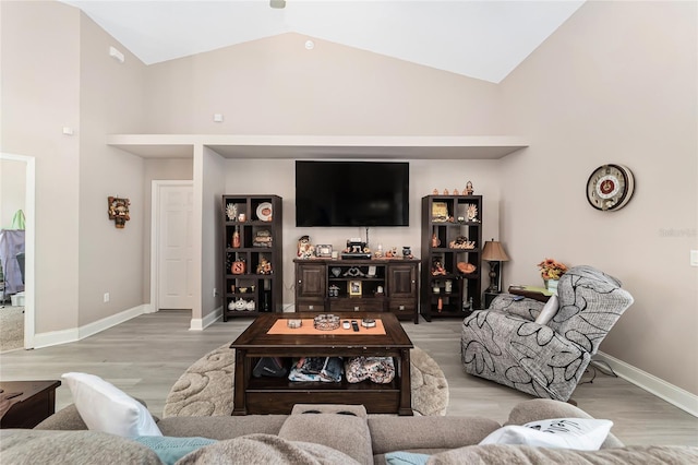 living room with high vaulted ceiling and light hardwood / wood-style floors