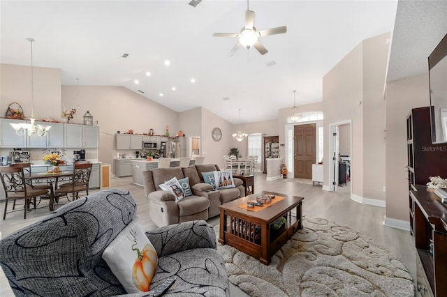 living room with light wood-type flooring, ceiling fan with notable chandelier, and high vaulted ceiling