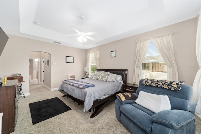 carpeted bedroom featuring multiple windows and ceiling fan