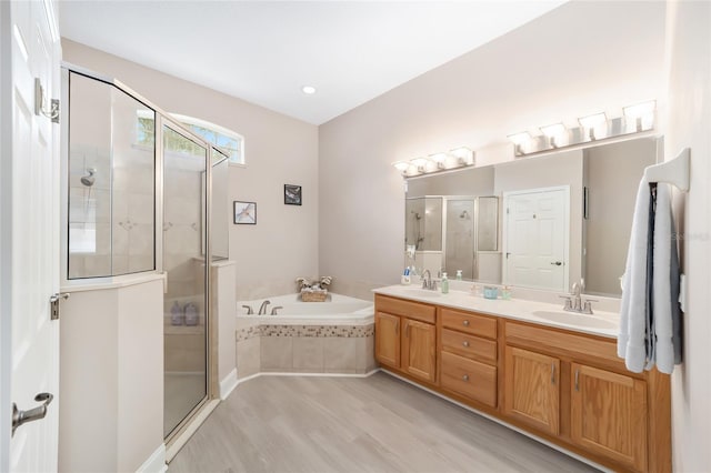 bathroom featuring hardwood / wood-style flooring, vanity, and plus walk in shower