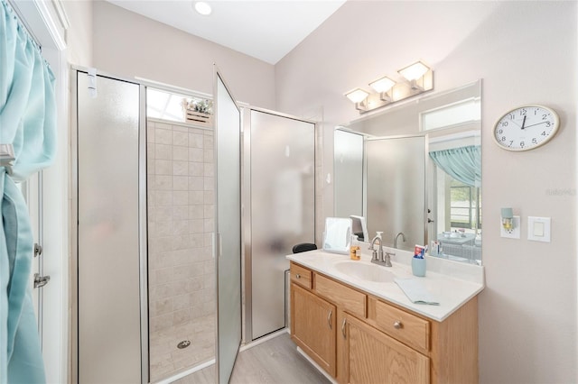 bathroom featuring hardwood / wood-style floors, a shower with shower door, and vanity