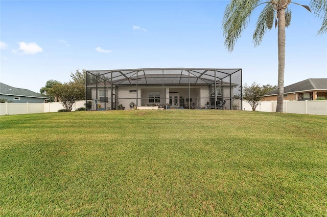 back of house with a lawn and a lanai