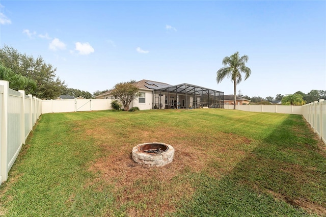 view of yard with a lanai and a fire pit