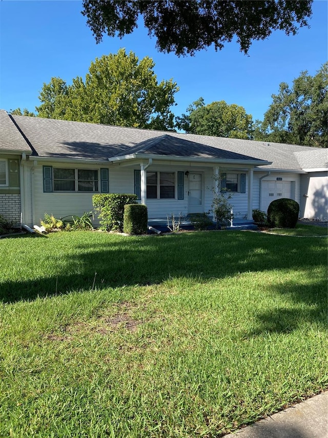 single story home with a garage and a front lawn