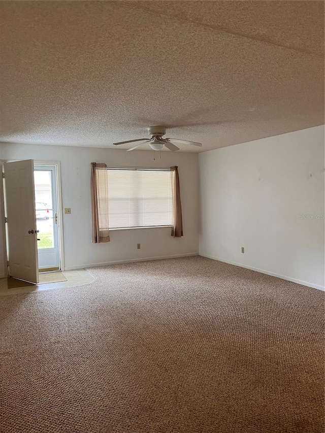 carpeted spare room featuring ceiling fan and a textured ceiling