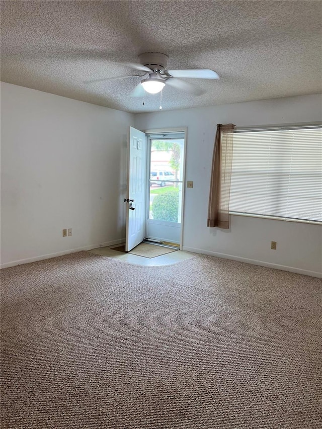 empty room with light colored carpet and a textured ceiling