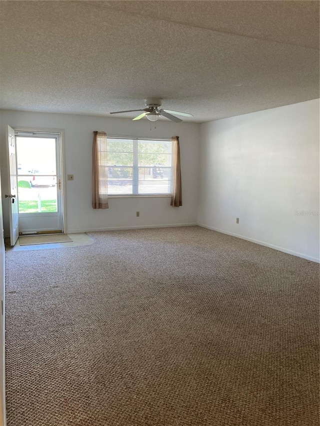 spare room with ceiling fan, a textured ceiling, and carpet floors