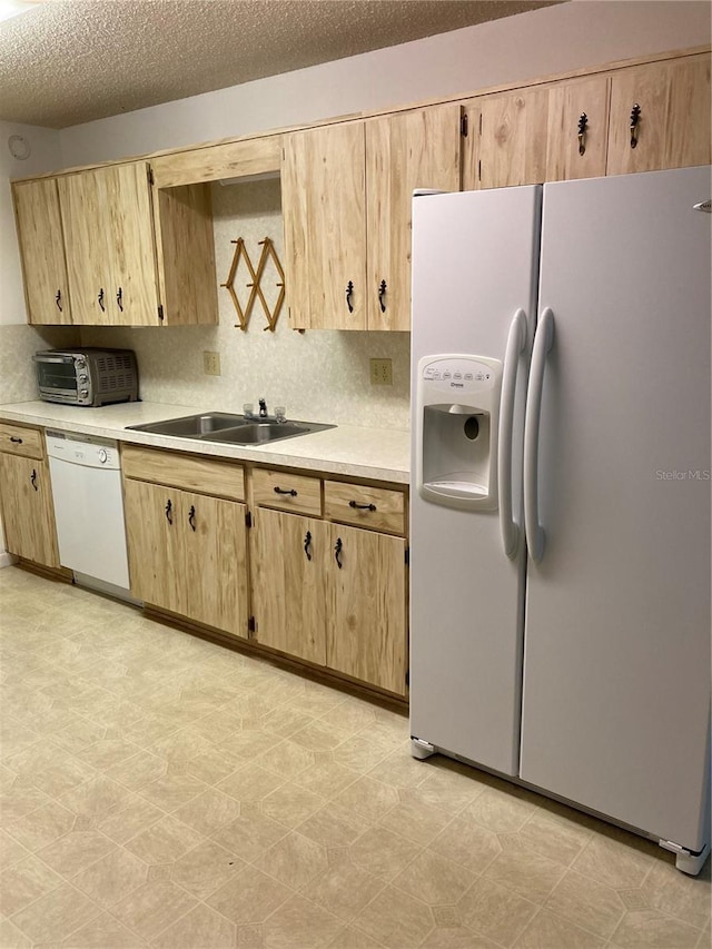 kitchen featuring decorative backsplash, a textured ceiling, sink, light brown cabinets, and white appliances