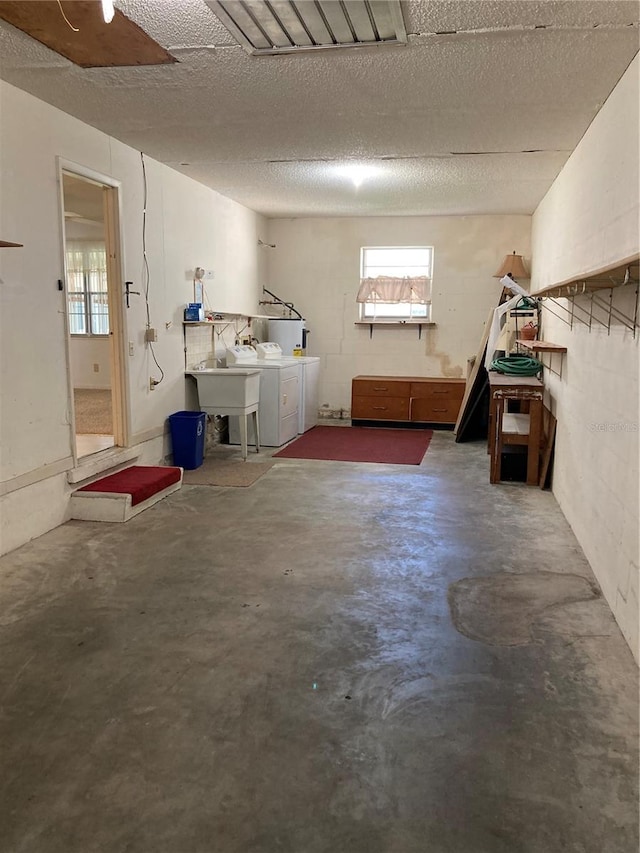 basement with washer and dryer and a textured ceiling