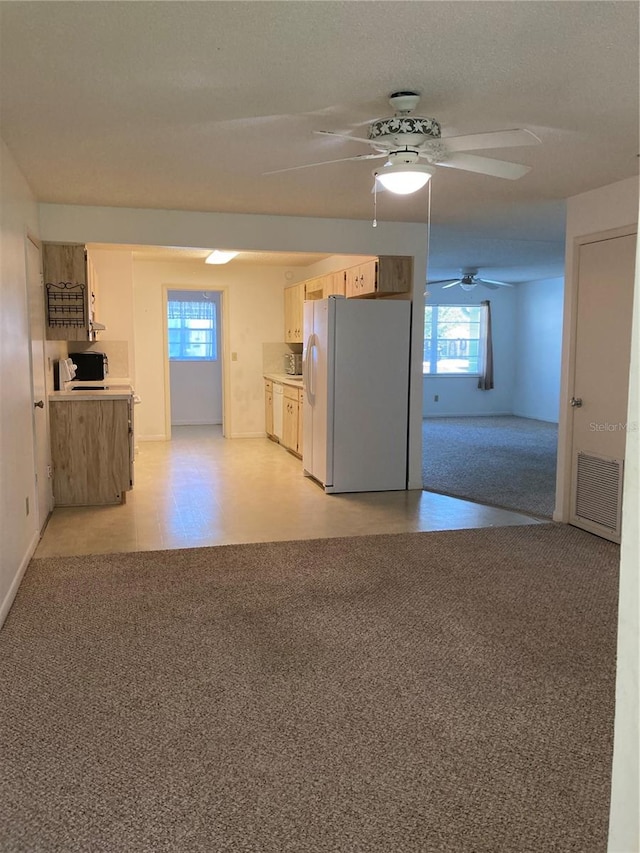 kitchen with ceiling fan and white refrigerator with ice dispenser