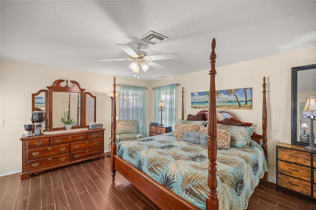 bedroom featuring dark wood-type flooring, a textured ceiling, and ceiling fan