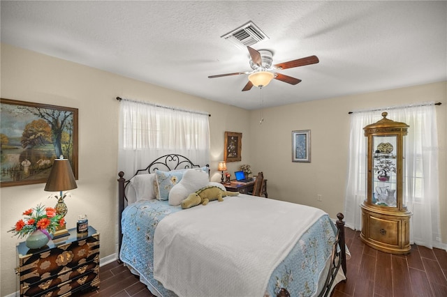 bedroom with dark hardwood / wood-style flooring, a textured ceiling, and ceiling fan