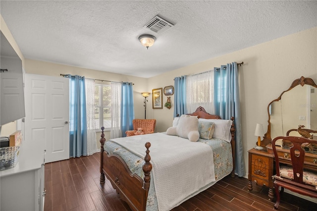 bedroom with dark wood-type flooring and a textured ceiling