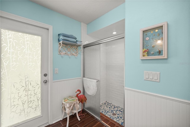 bathroom featuring hardwood / wood-style flooring and a tile shower