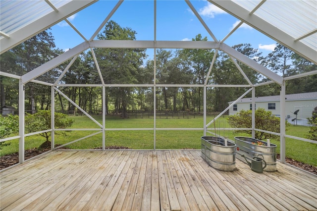 deck featuring glass enclosure and a yard