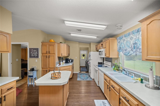 kitchen featuring sink, dark hardwood / wood-style floors, white appliances, a kitchen island, and vaulted ceiling