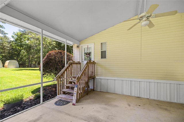 unfurnished sunroom featuring ceiling fan and vaulted ceiling