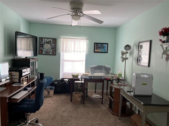 carpeted office space with a textured ceiling and ceiling fan