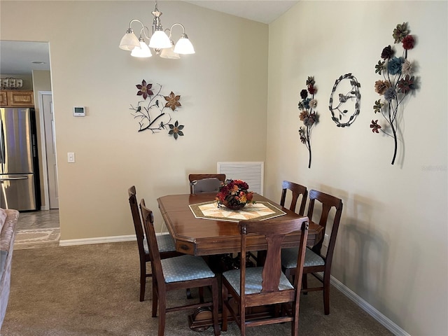 dining area featuring a chandelier and carpet flooring