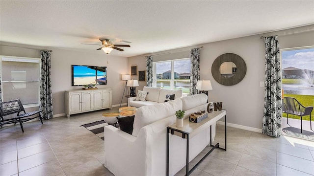 living room featuring a textured ceiling, ceiling fan, and light tile patterned flooring