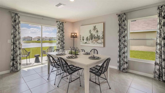 tiled dining room featuring a water view