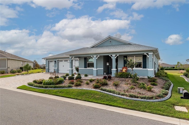 view of front of house featuring a garage, a porch, and a front lawn