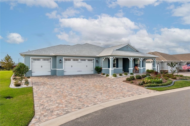 view of front of property with a garage, a front yard, and covered porch