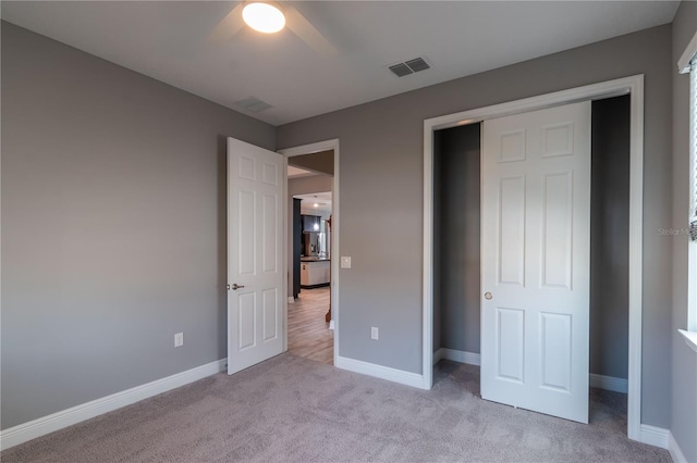 unfurnished bedroom with a closet, light carpet, and ceiling fan